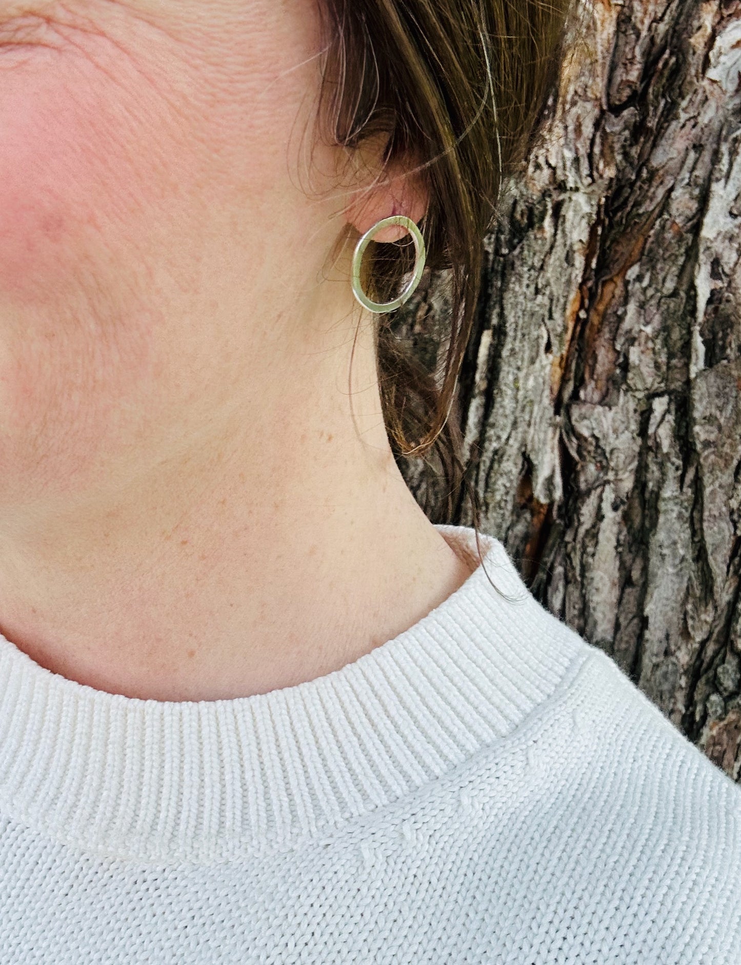 Silver circle stud earrings being worn, showing approximate size (2 cm).