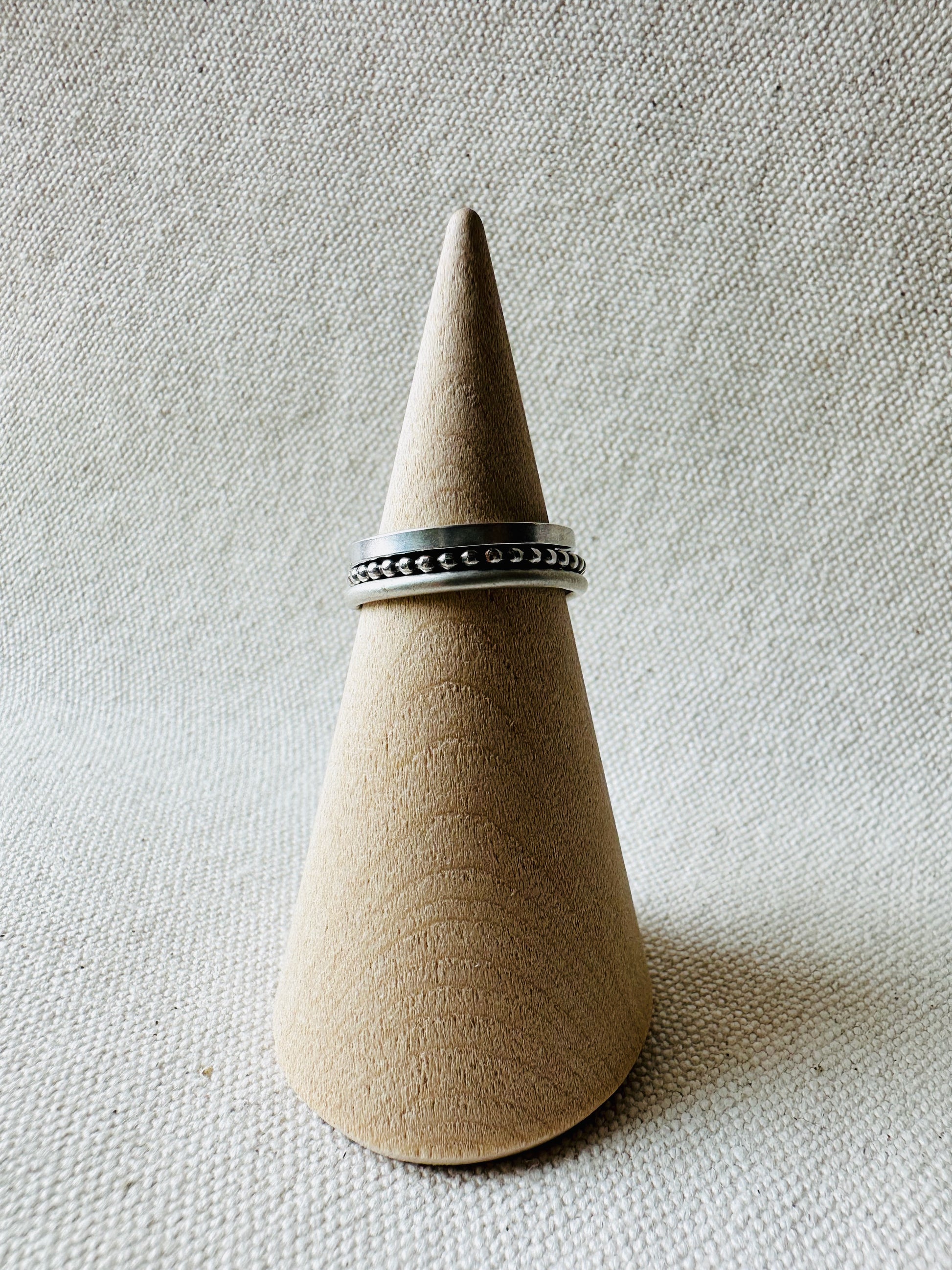 Silver stacking rings on wooden ring holder. 