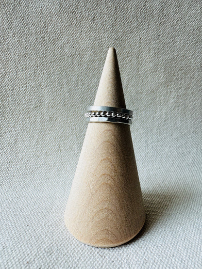 Stacking silver rings on wooden ring holder. 