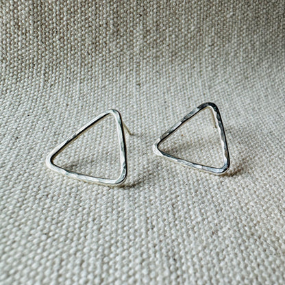 Close-up image of silver hammered triangle stud earrings, approximate size (2 cm).