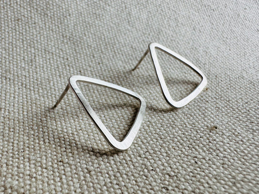 Close up image of silver (2 cm) open triangle stud earrings with satin texture. 