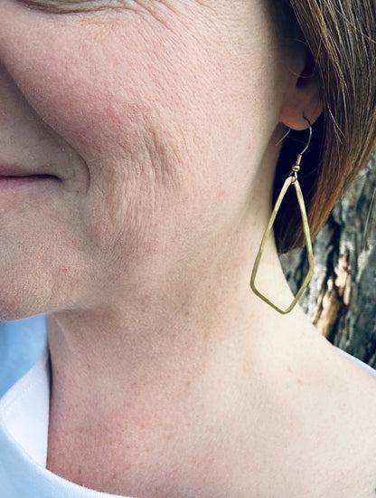 Brass geometric dangle earrings being worn, showing approximate size (5 cm plus ear wire length).