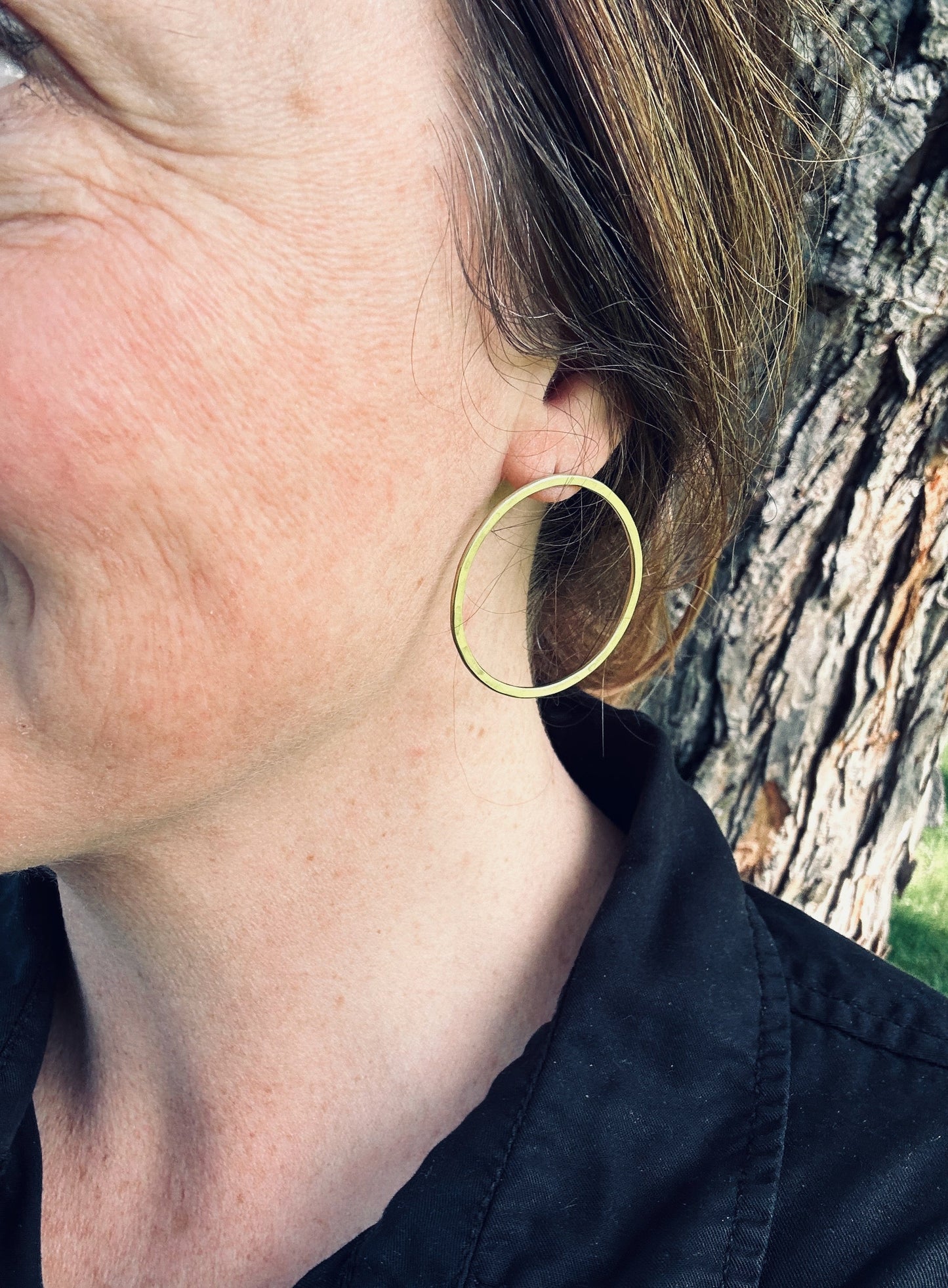 Brass satin circle stud earrings being worn, showing approximate size (4 cm).