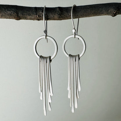 Pair of silver circle dangle earrings with fringe with satin finish.