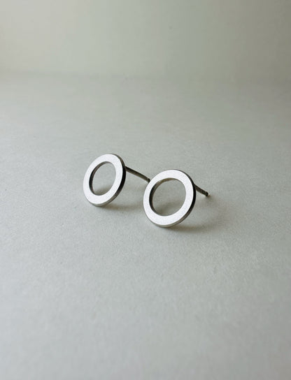 Pair of silver circle earrings on a light gray background
